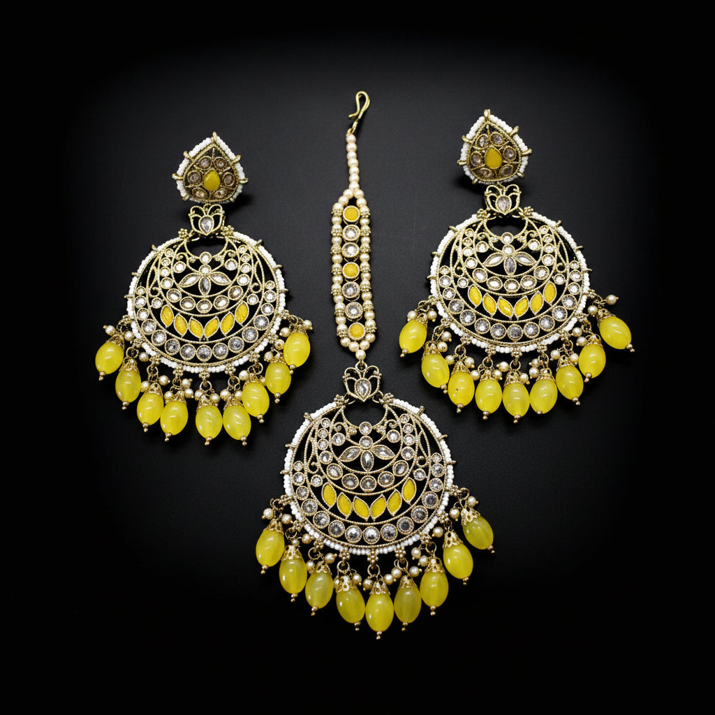 Set of gold and yellow earrings on a dark background
