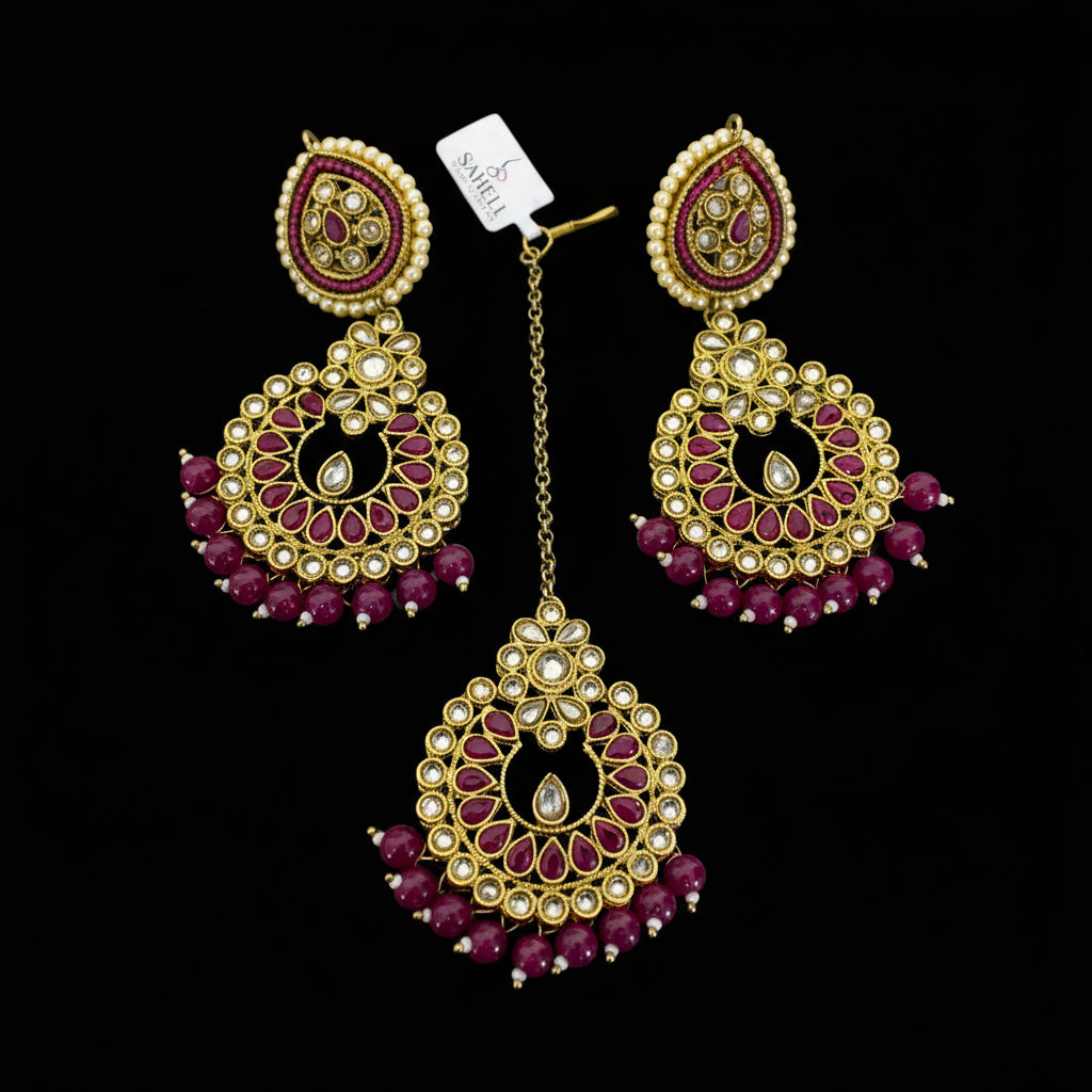 Pair of gold and red gemstone earrings on a gray background
