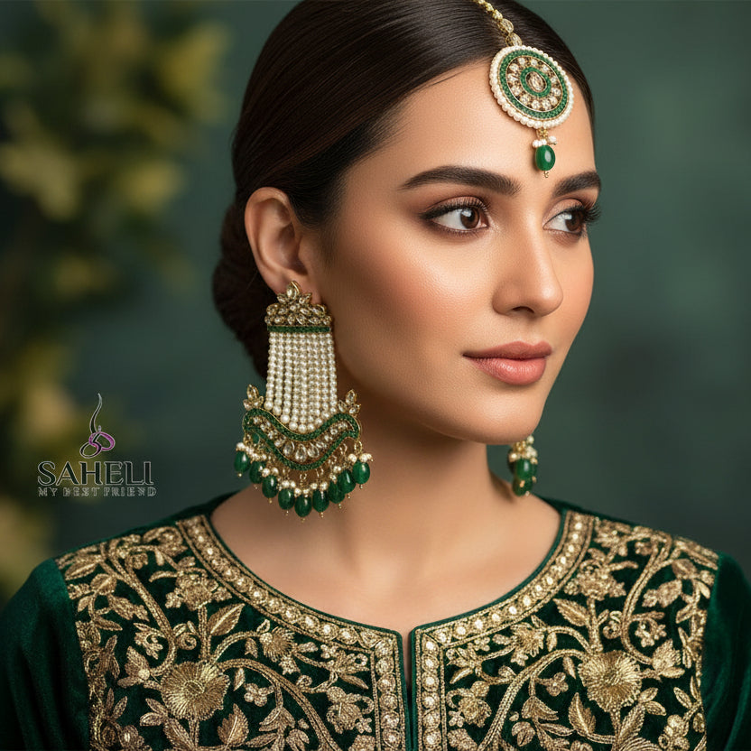 Ornate earrings with green and gold details on a dark background