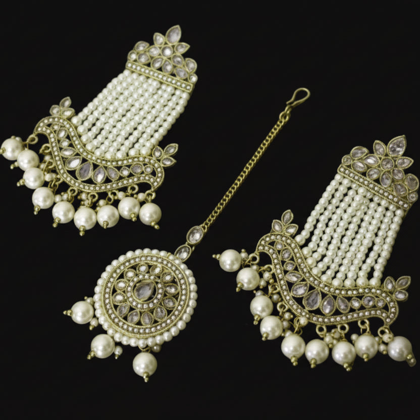 Set of pearl and gold jewelry on a dark background
