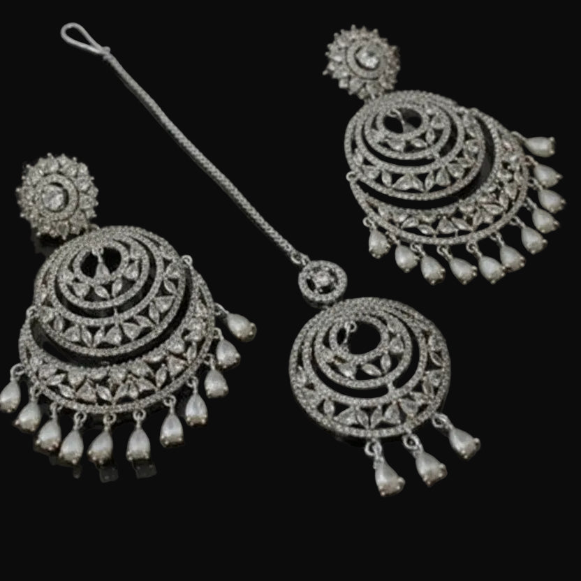 Ornate silver earrings on a dark background