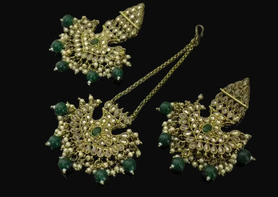 Gold and green jewelry set on a dark background