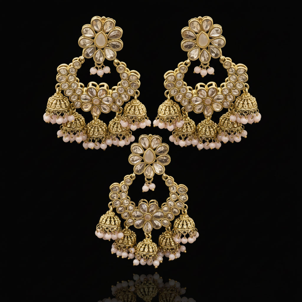 Gold and pearl earrings on a black stand with 'Saheli' branding.