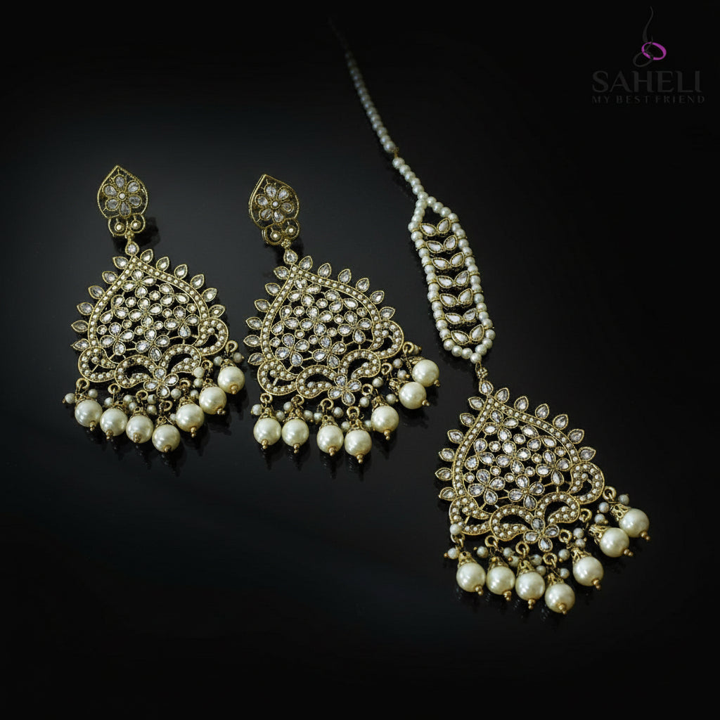 Jewelry set with earrings and a necklace on a dark background, featuring the brand 'Saheili'.