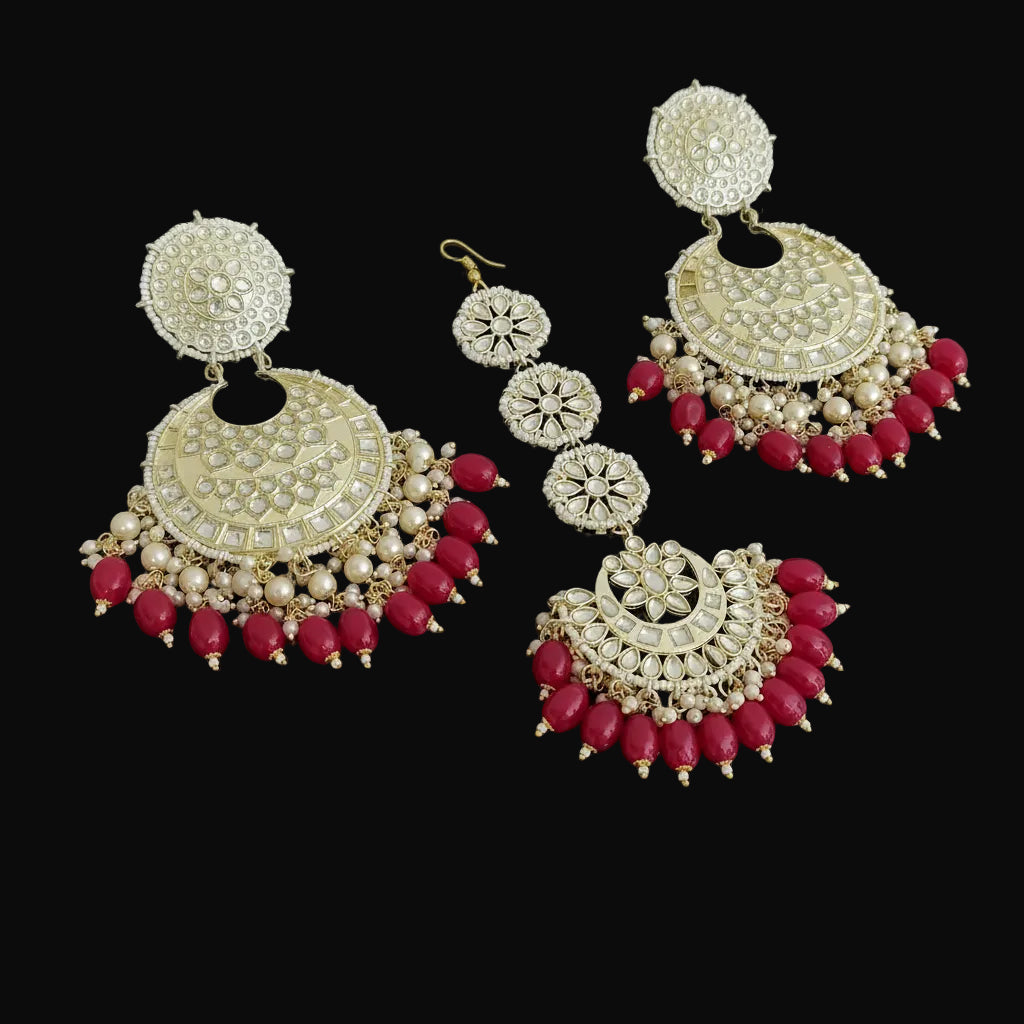 Set of gold and red earrings on a black background