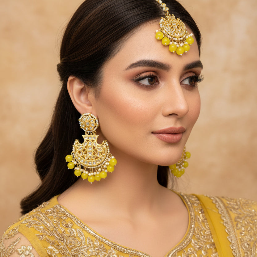 Gold and green beaded earrings on a black background