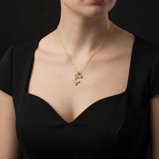 Gold necklace with butterfly pendant on a branded card against a black background