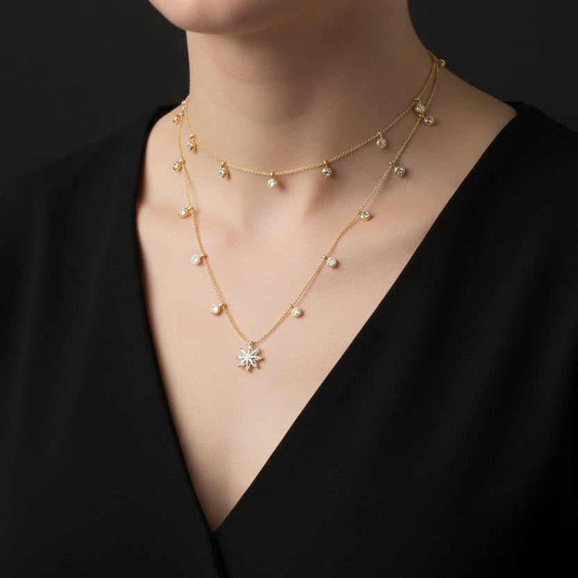 Gold necklace with a star-shaped pendant on a black background
