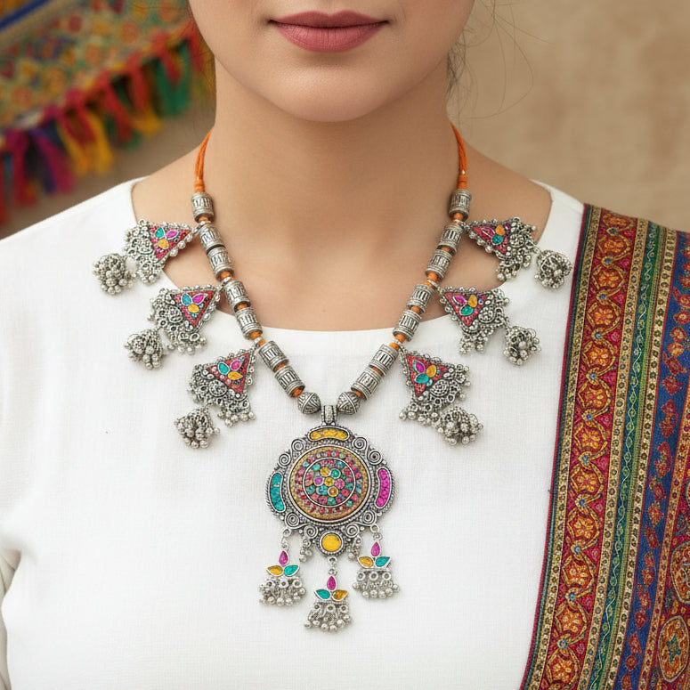 Decorative necklace with colorful pendants on a gray background, featuring the brand 'Saheli'.