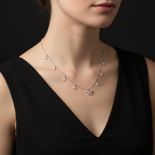 Delicate necklace with butterfly pendant and teardrop-shaped crystals on a black background