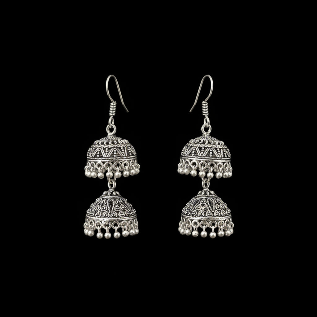 Silver earrings on a gray stand with 'Sahell' branding.