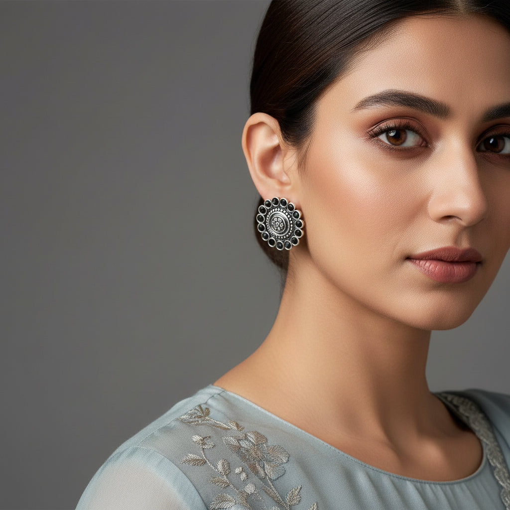 Pair of silver floral earrings on a black background