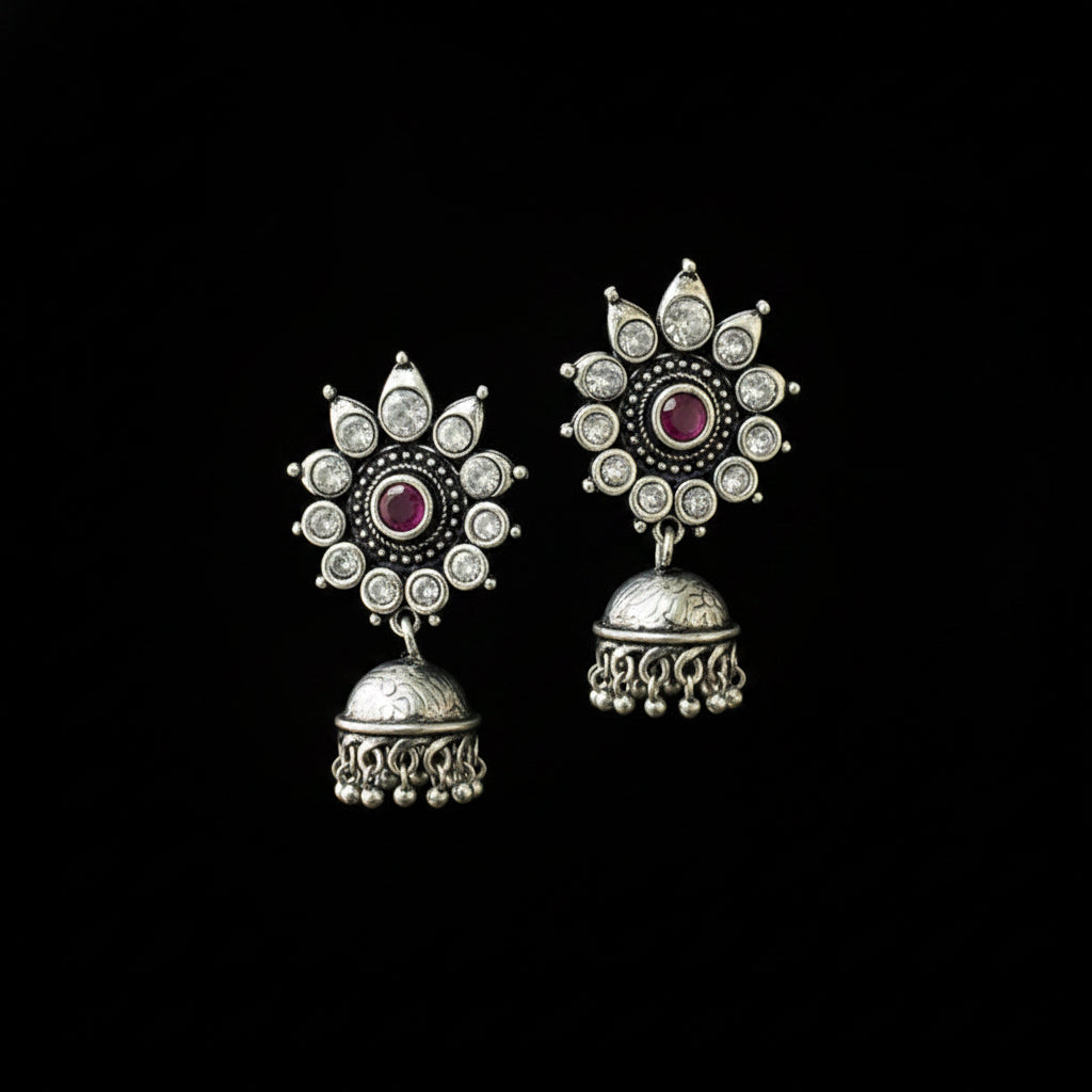 Silver earrings with red gemstones on a black background