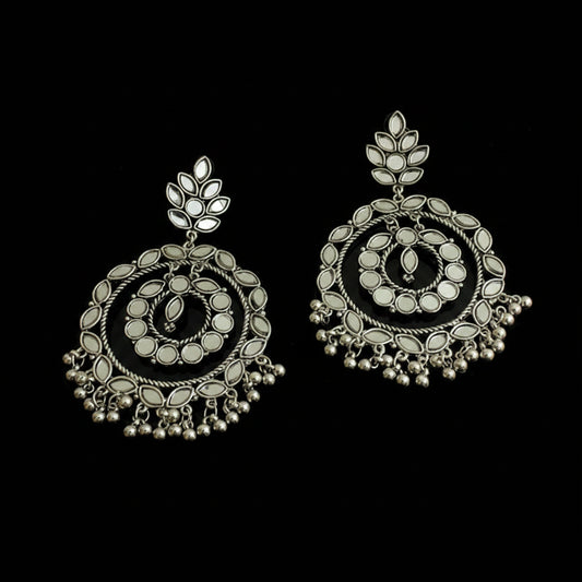 Pair of silver earrings with intricate designs on a black background