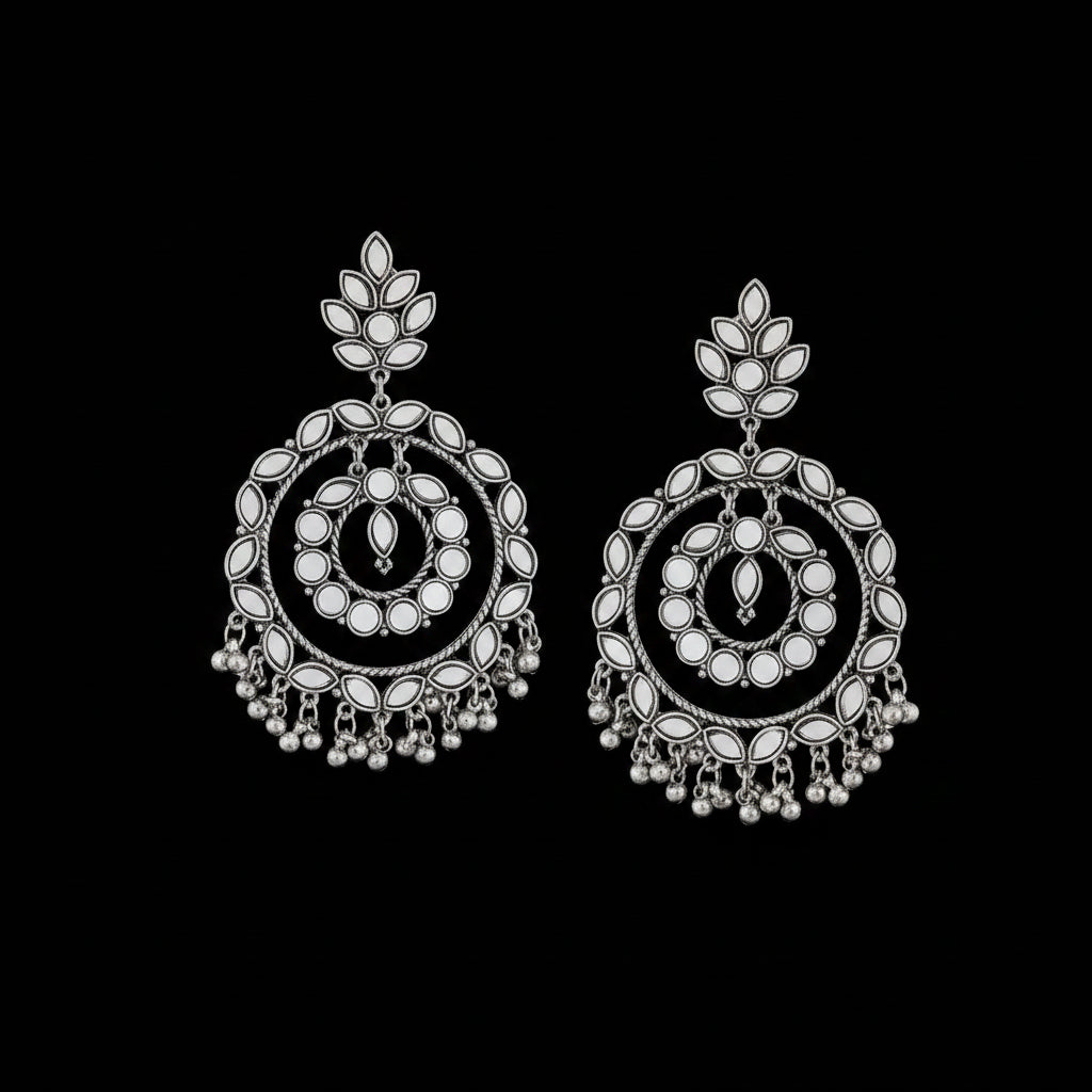 Pair of silver earrings with intricate designs on a black background