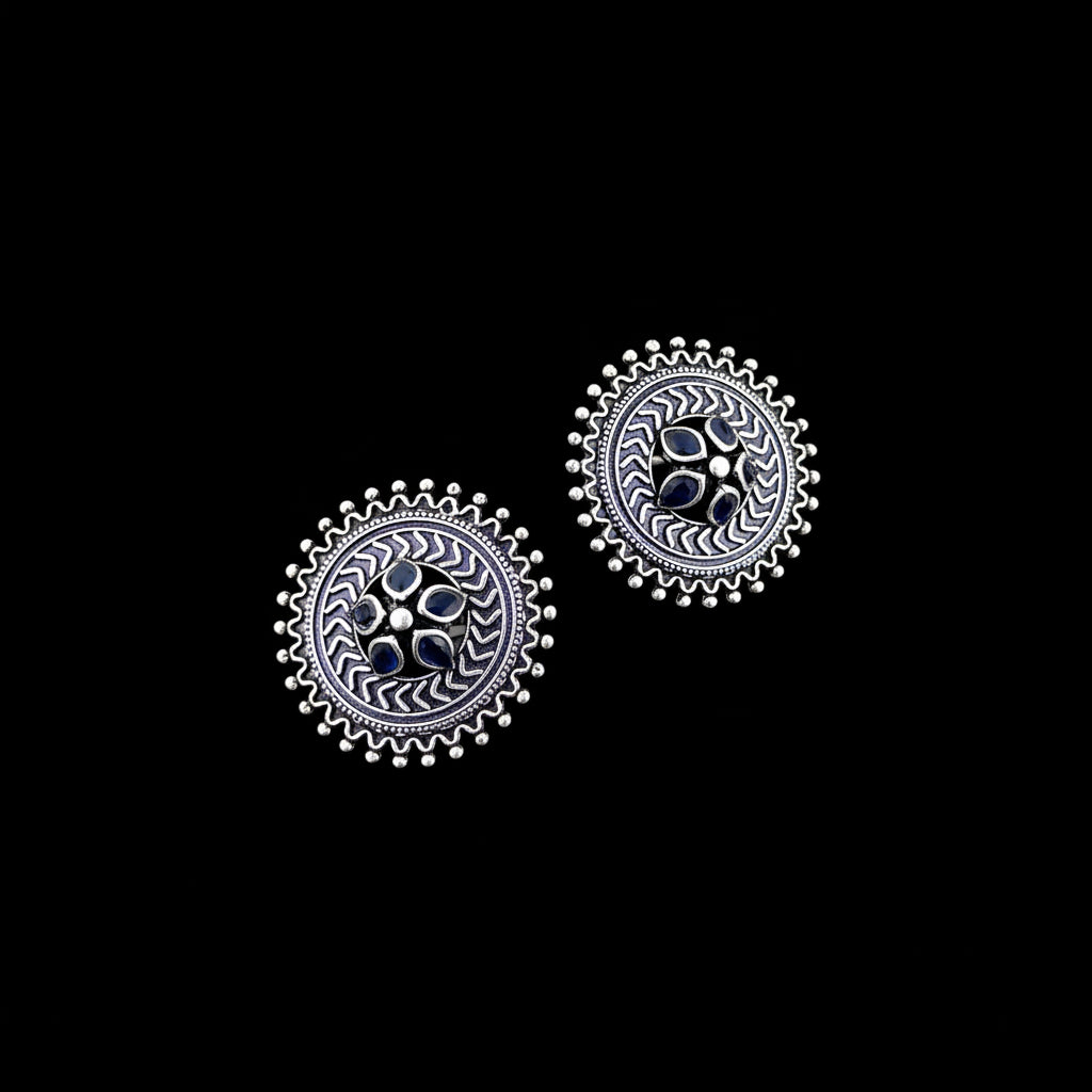 Pair of silver earrings with blue gemstones on a gray background