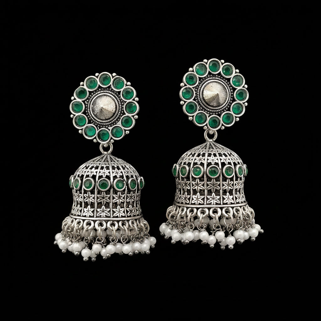 Pair of silver and green earrings on a gray stand with a blurred background