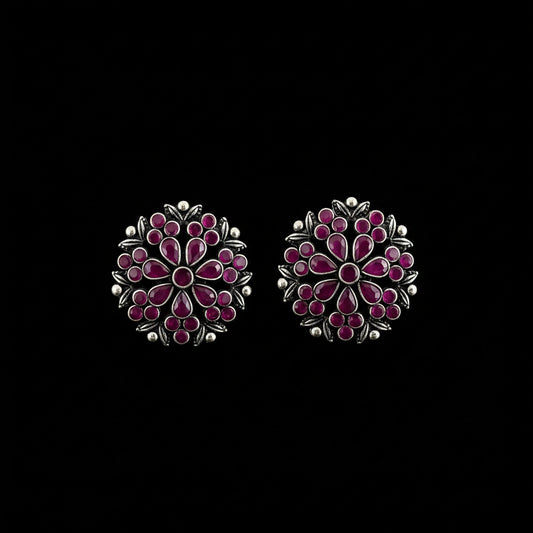 A pair of silver-toned Indian Kundan earrings decorated with pink and red stones, displayed on a dark gray reflective surface with the brand name 'SAHELI MY BEST FRIEND' printed at the top.