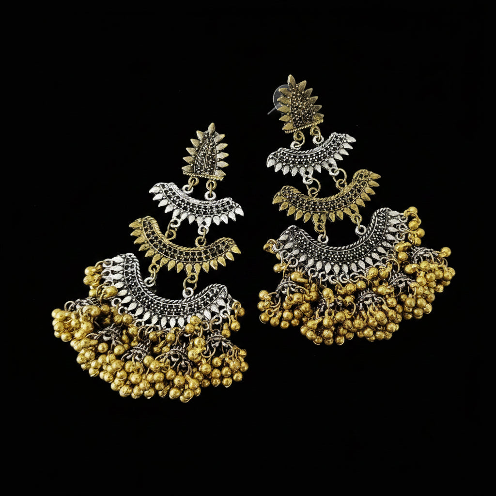 Pair of gold and silver earrings with 'SAHELI' branding on a dark background