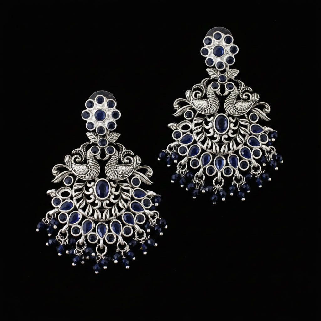 Ornate silver and blue earrings on a gray background