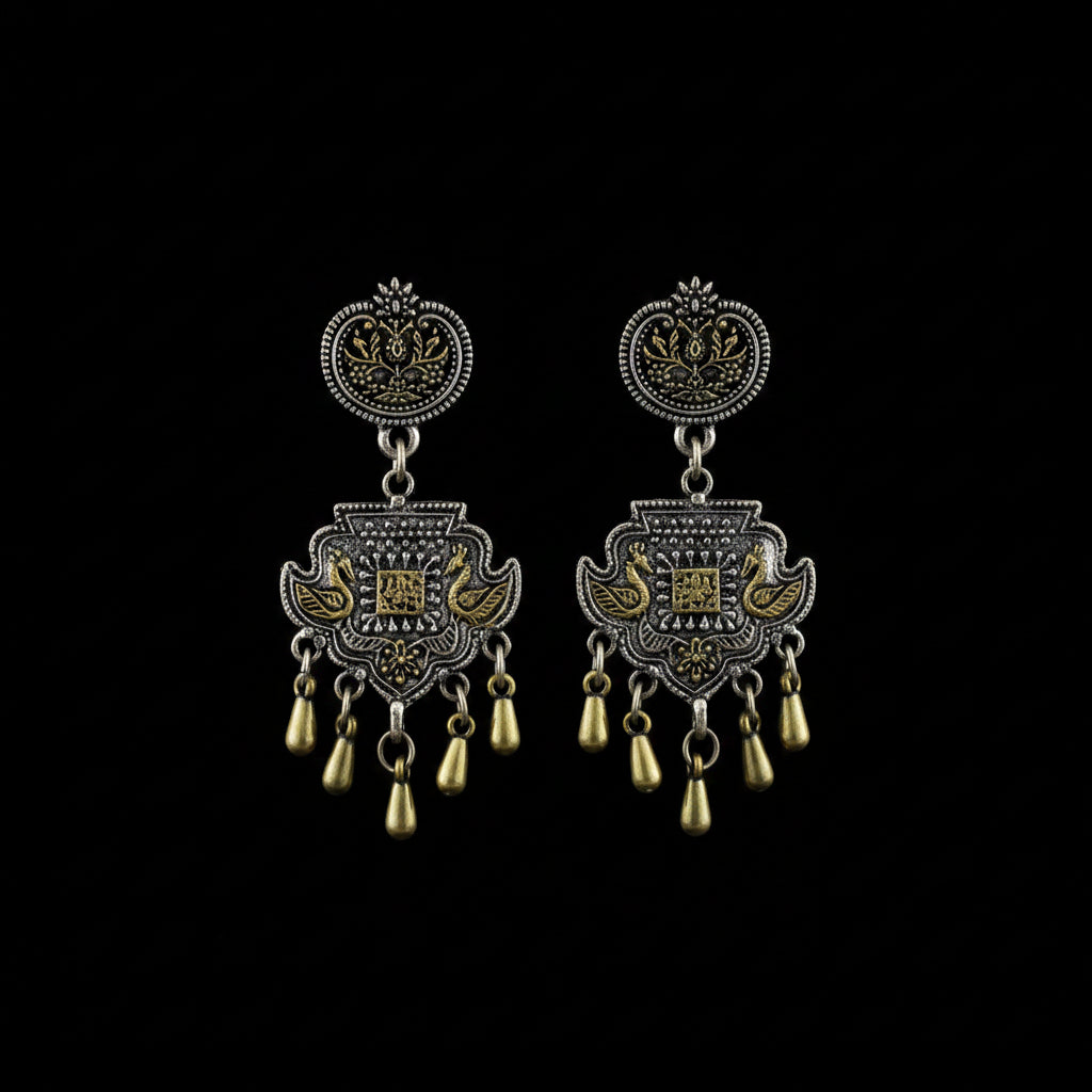 A pair of ornate Indian silver-toned chandelier earrings with gold-toned accents, displayed on a dark gray background with the Sahelli by the Sea Friend brand logo above them.