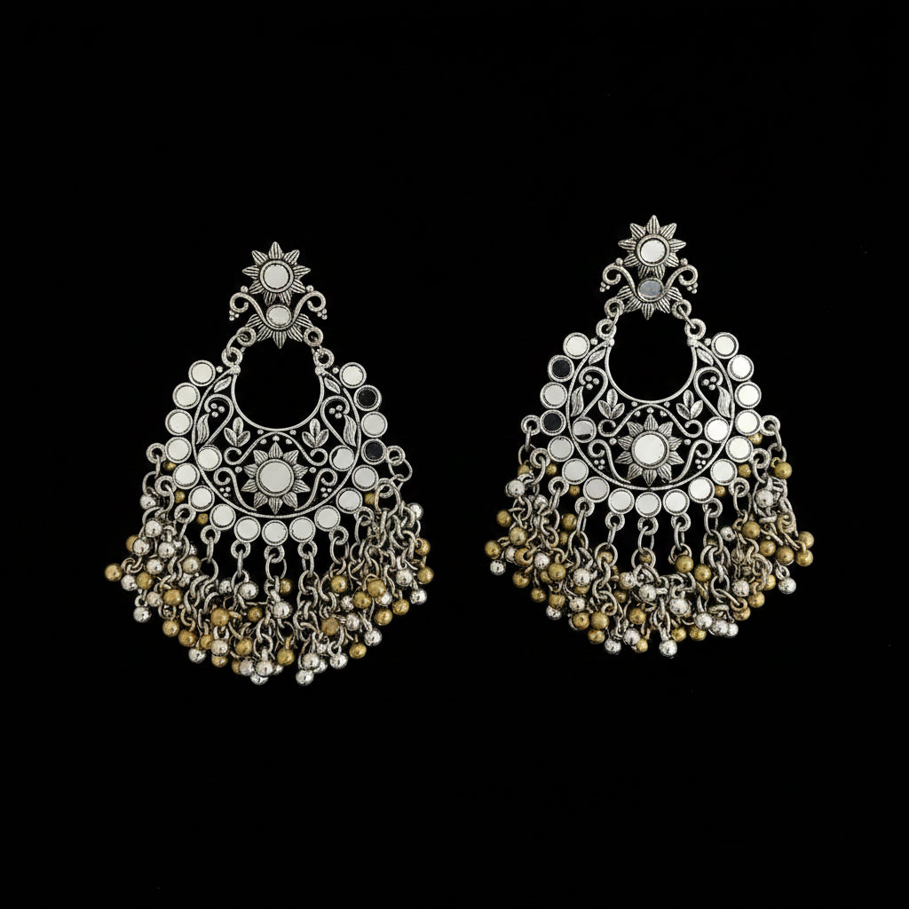 A pair of ornate silver-toned Indian jhumka earrings decorated with white faux pearls and gold-toned beads, displayed on a dark reflective surface with a 'SAHIEL MY BEST FRIEND' watermark.
