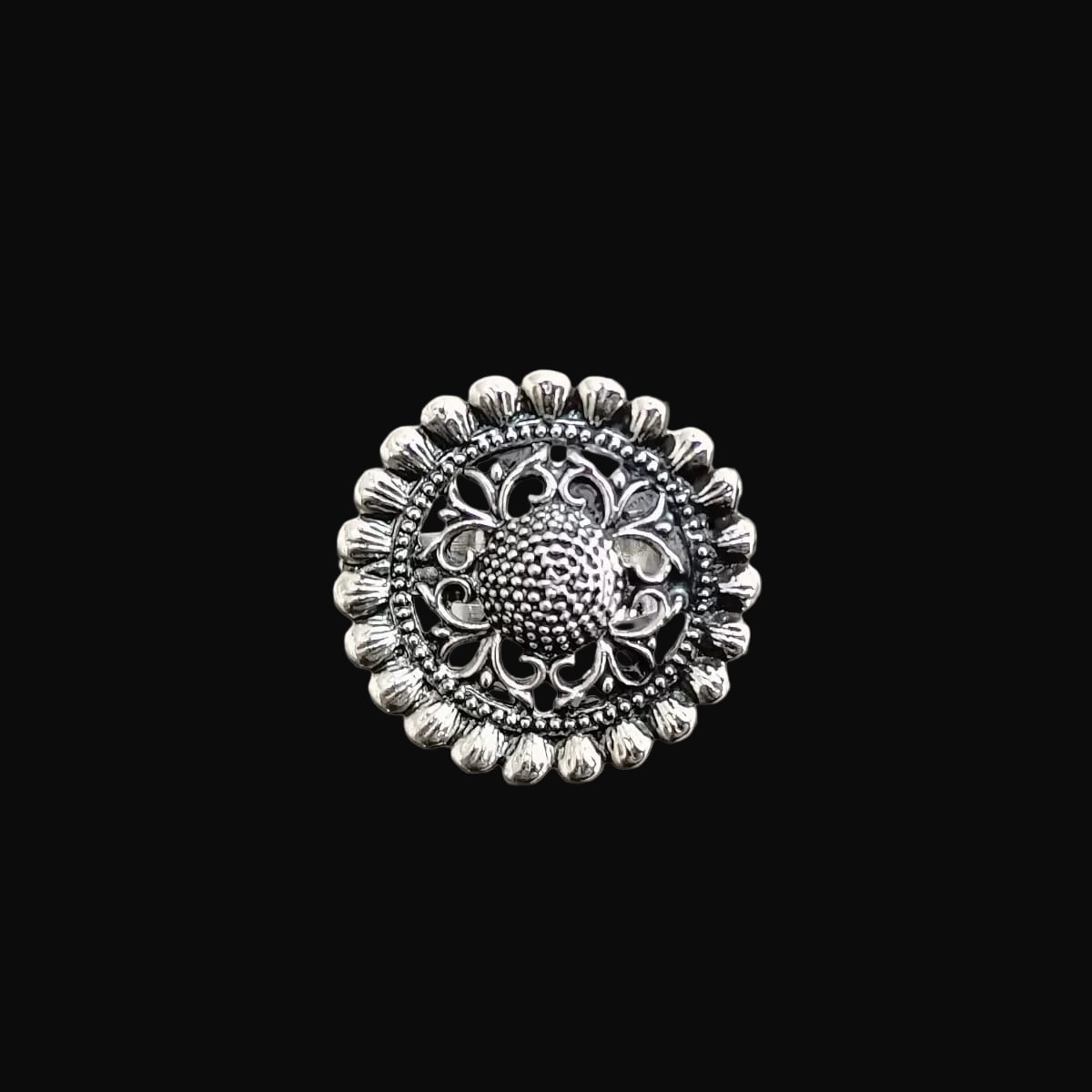 Silver decorative button on a black background