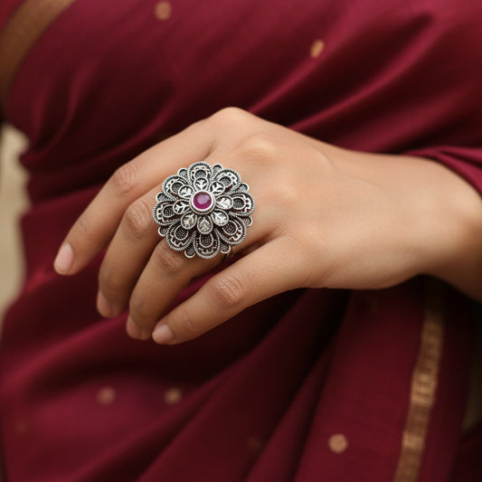 Decorative ring with a red gemstone on a dark gray background