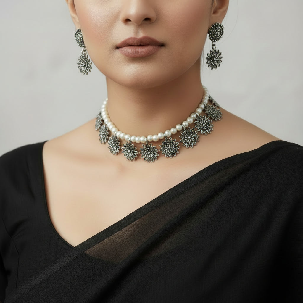 Jewelry set with necklace and earrings on a light gray background, featuring the brand 'Saheli'.
