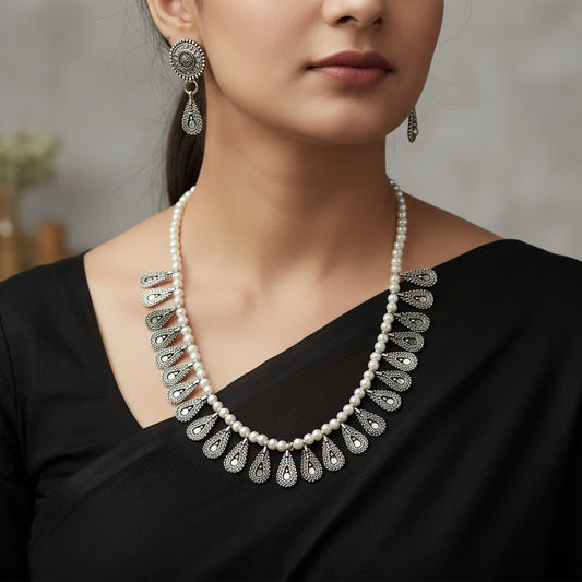 Pearl necklace with silver decorations on a white background, featuring the brand 'Saheli'.