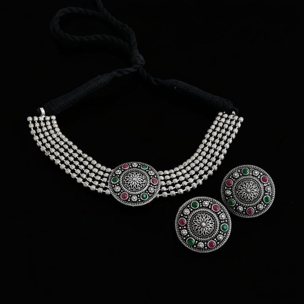 Silver necklace with colorful gemstones on a dark surface