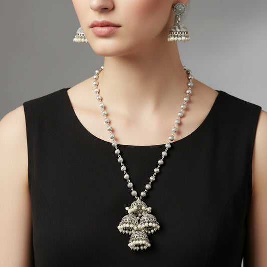 Silver necklace with pendant and earrings on a gray background, featuring the brand 'SAHELI'.