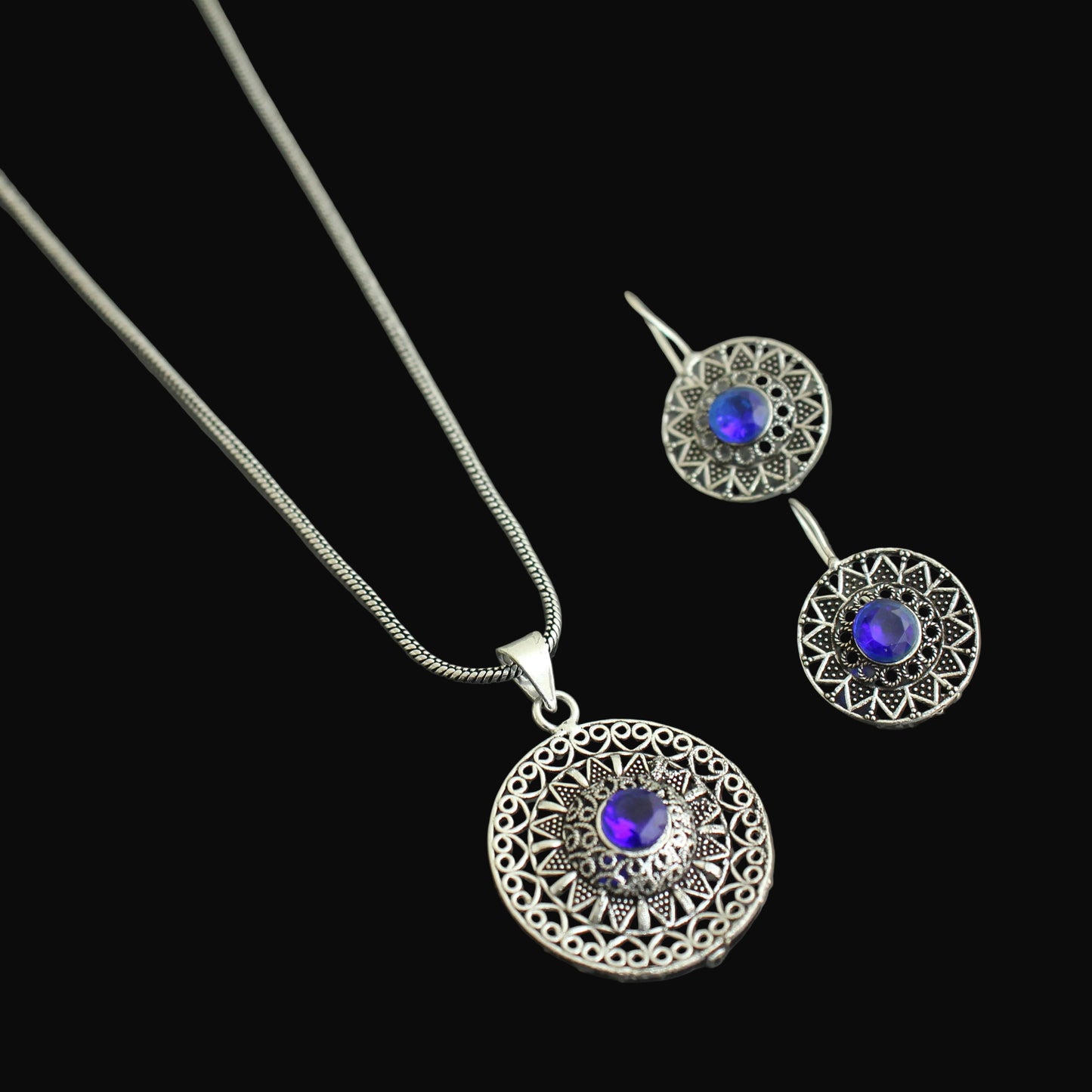 Silver necklace and earrings with blue gemstones on a gray background