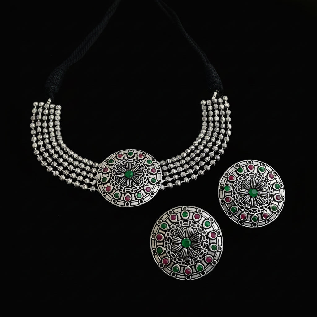 Silver necklace with circular pendants on a dark surface