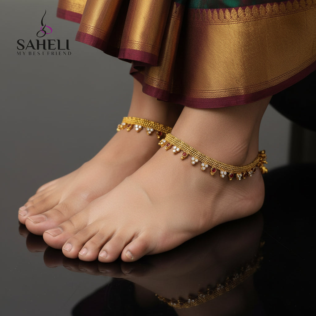 Gold necklace with red and white stones on a gray background, branded 'Saheli'.