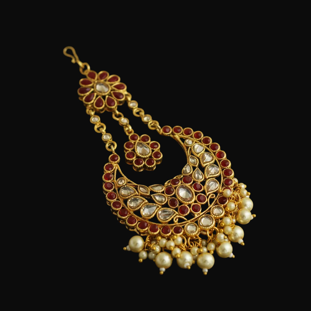 Ornate gold necklace with red and white stones on a black background