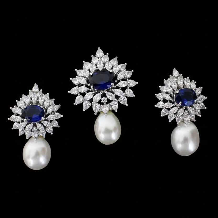 Set of diamond and pearl earrings with blue gemstones on a dark background