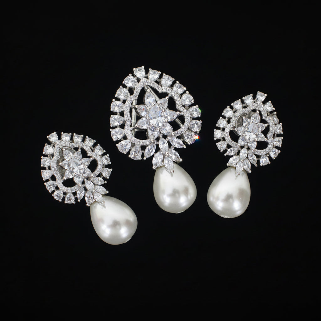 Pair of silver earrings with pearl drops on a black background