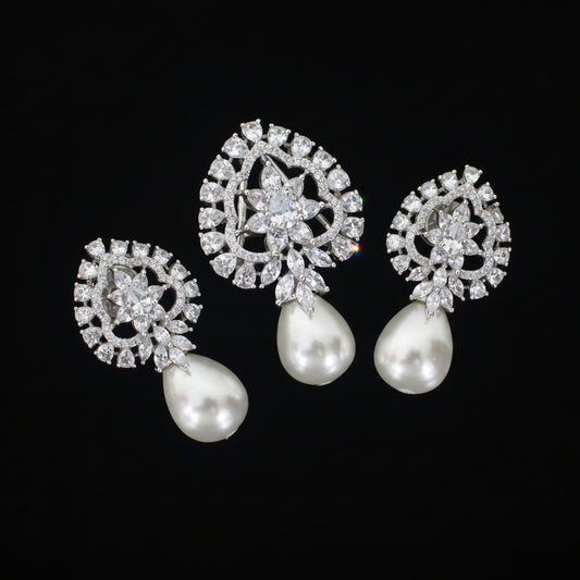 Pair of silver earrings with pearl drops on a black background