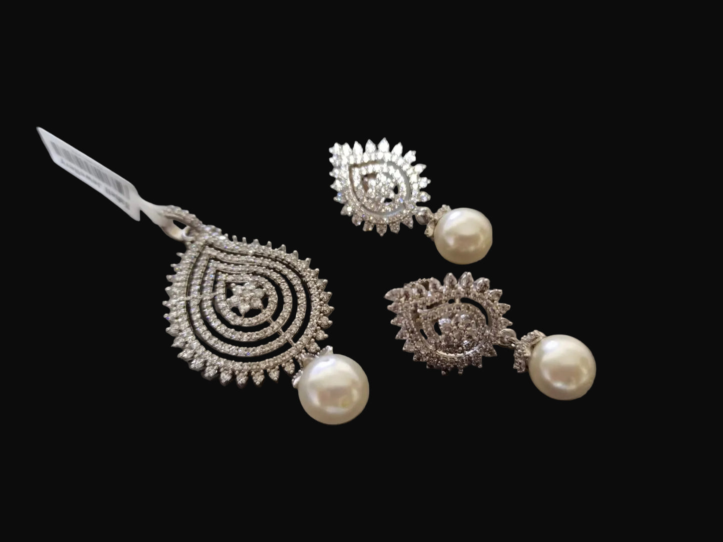 Silver earrings with pearls on a laptop keyboard