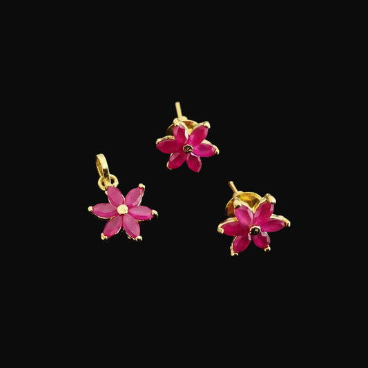 Gold and pink flower-shaped earrings on a gray background with 'SAHELL' branding.