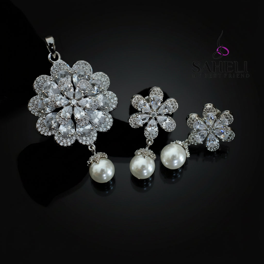 Silver floral jewelry set with pearls on a dark background, branded 'Saheli'.