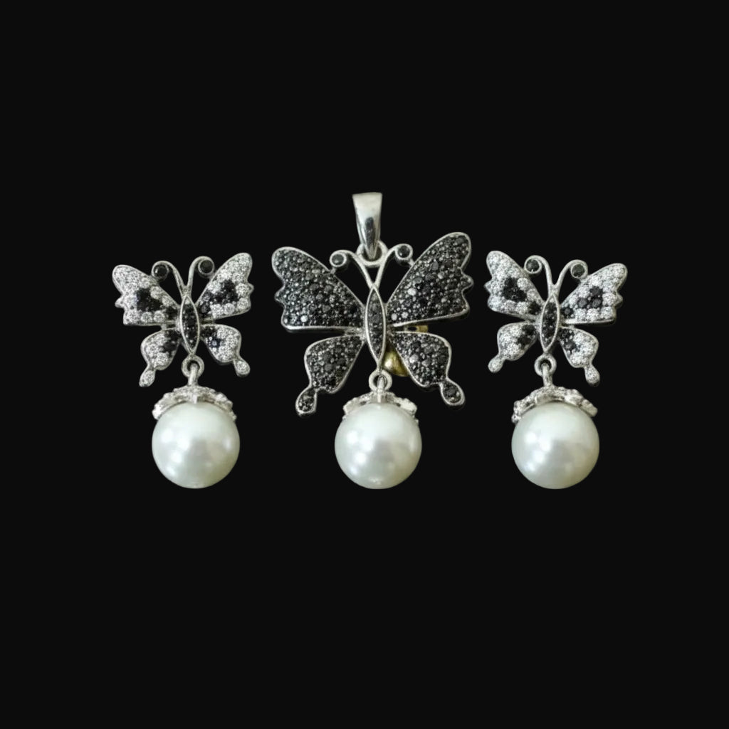 Butterfly-shaped earrings with pearl drops on a dark background, featuring the brand 'Saheli'.
