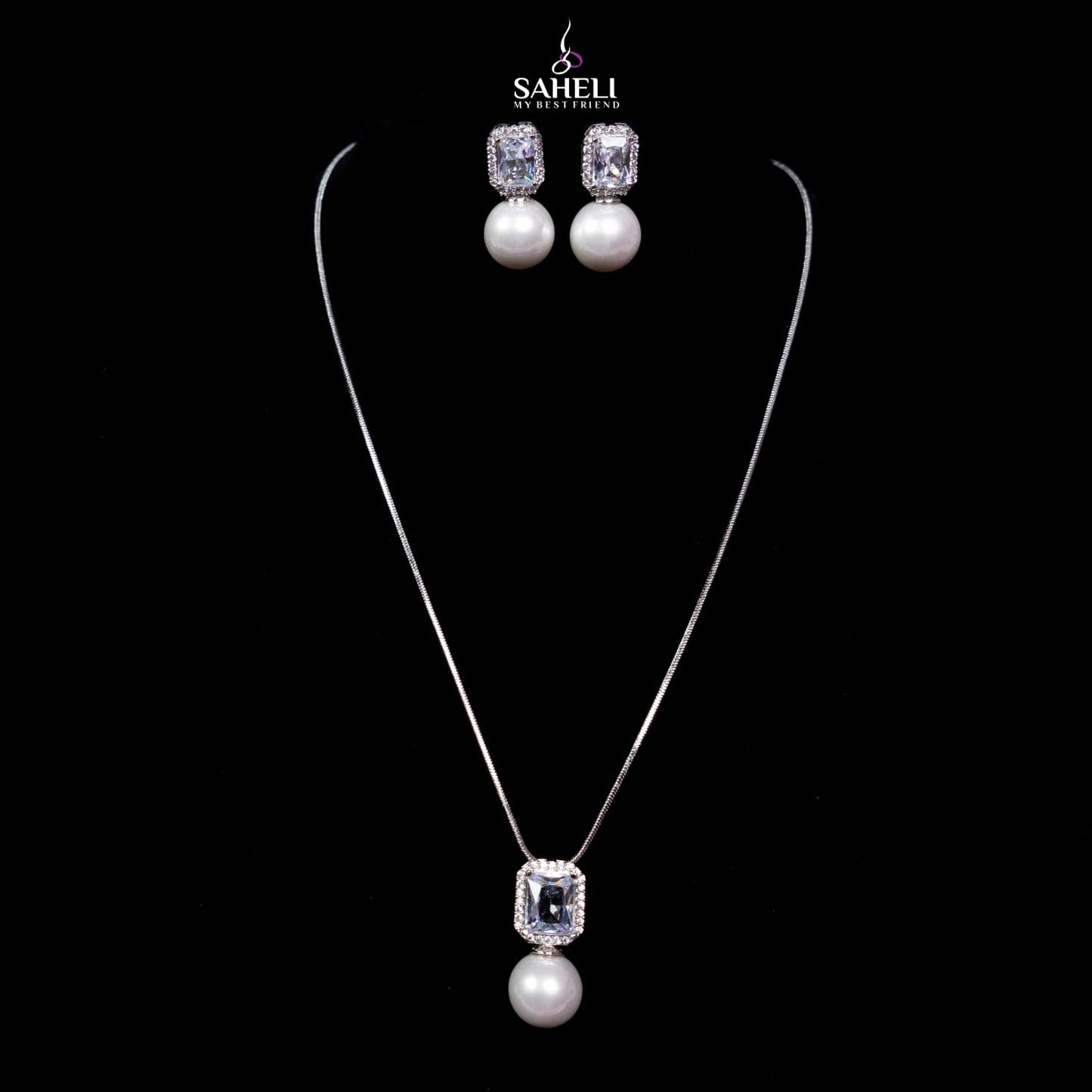 Jewelry set with necklace and earrings on a black background, featuring the brand 'Saheli'.