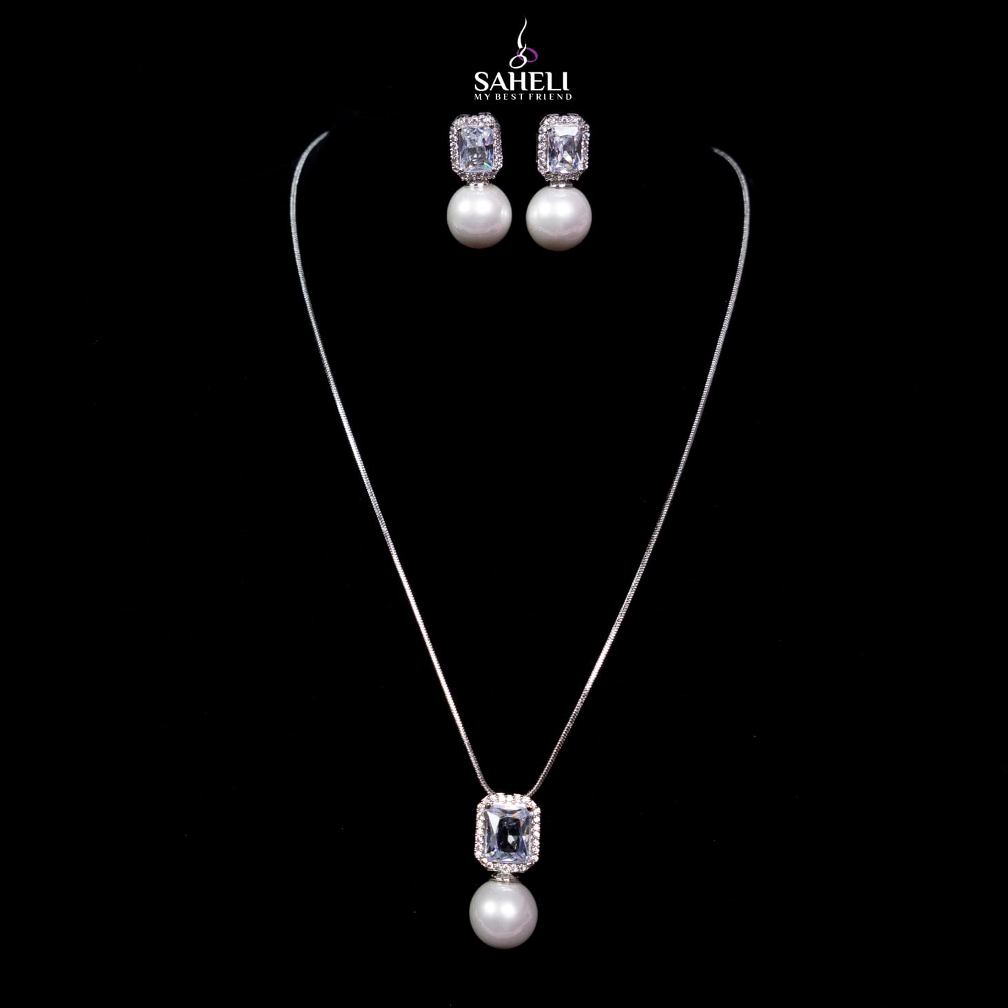 Jewelry set with necklace and earrings on a black background, featuring the brand 'Saheli'.