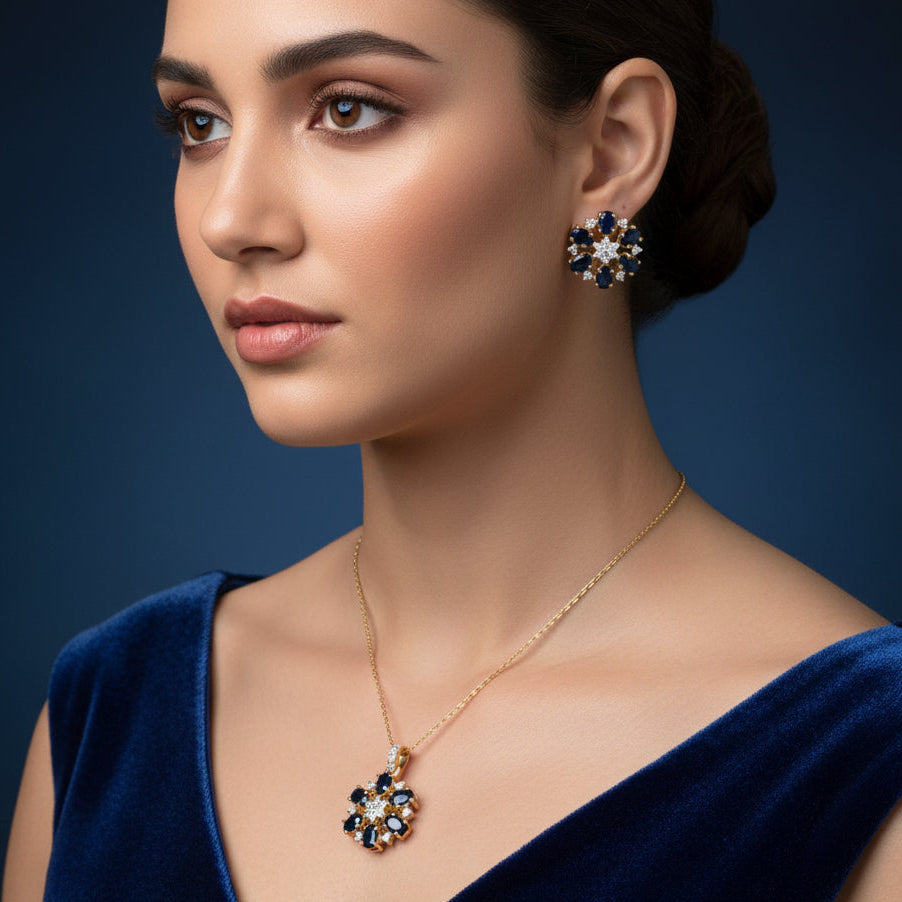 Gold and blue gemstone earrings on a gray background with 'SAHELLI' branding.