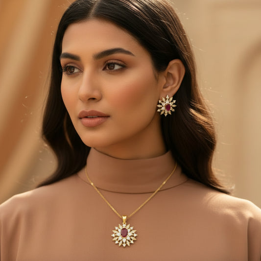 Gold earrings with red gemstones on a dark background, featuring the brand 'Saheli'.