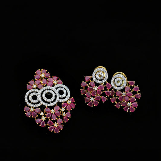 Pair of ornate earrings with pink gemstones and gold accents on a dark background, branded 'Saheili'.