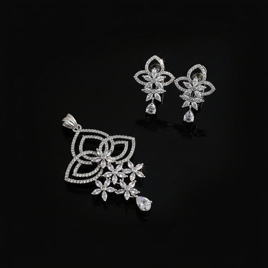 Silver jewelry set with pendant and earrings on a dark background, featuring the brand 'Saheli'.