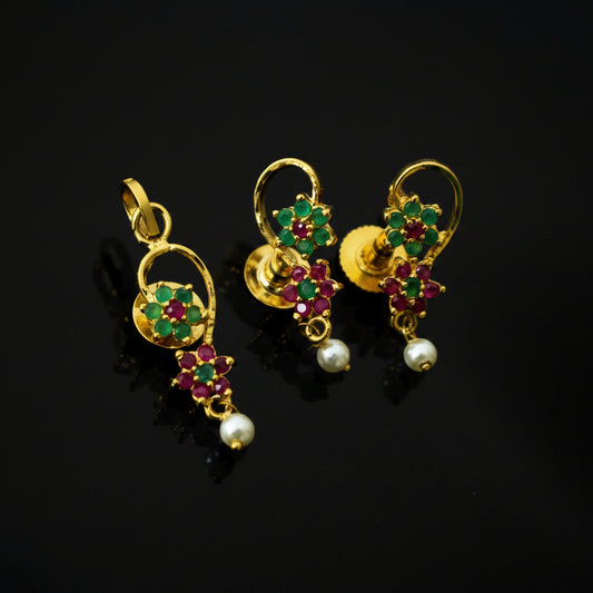 Gold earrings with gemstones and pearls on a gray background, branded 'SAHELI'.